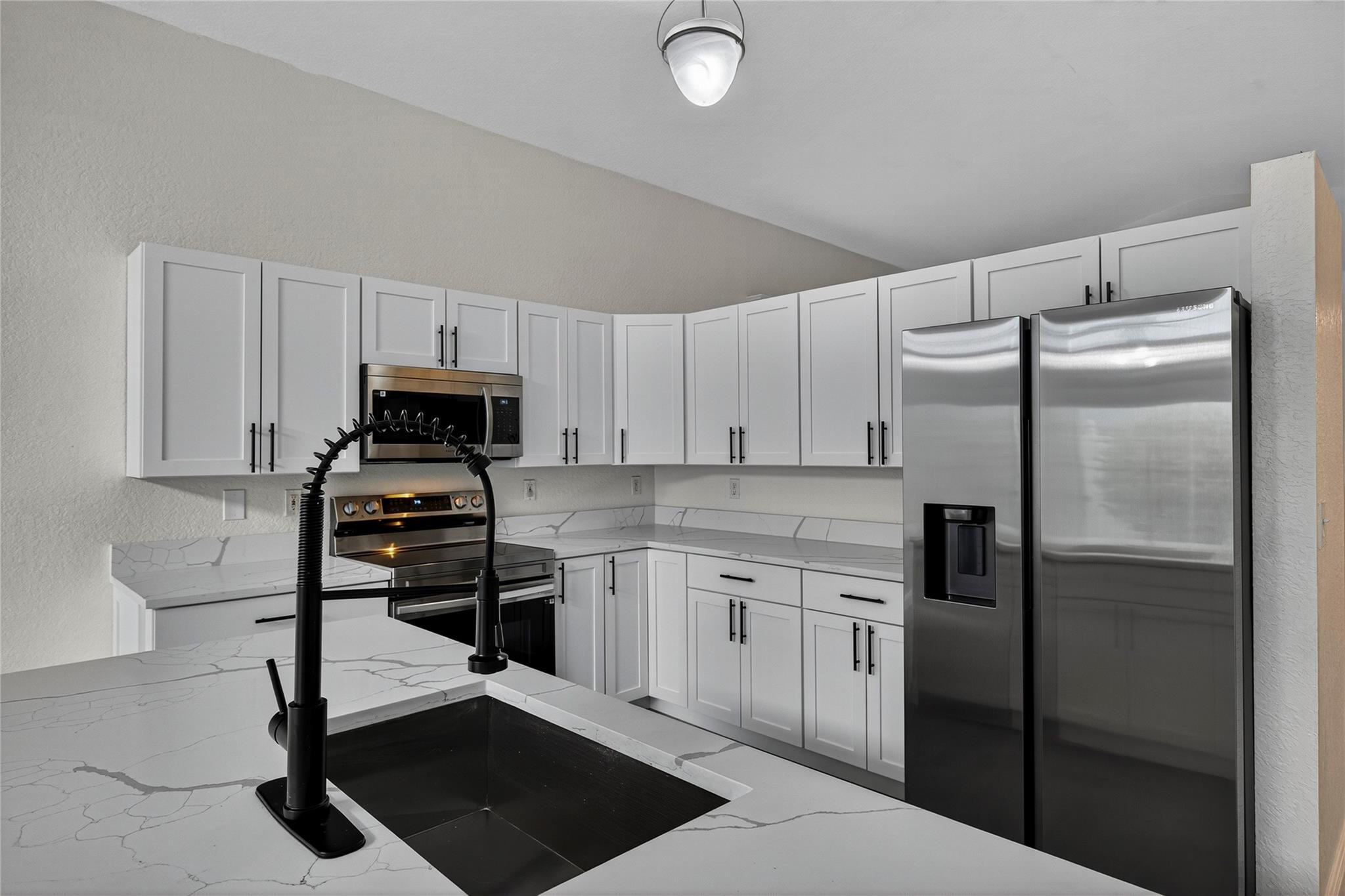 2424 Southwest 162nd Avenue Miramar, FL 33027 - Photo 7 of 44 a kitchen with stainless steel appliances a stove a refrigerator and white cabinets