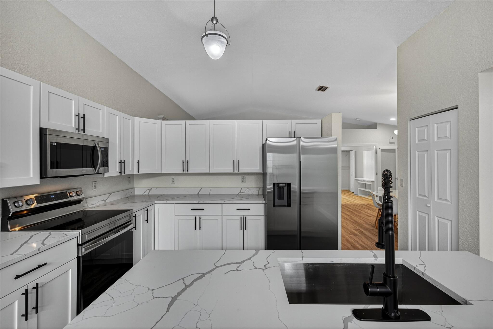 2424 Southwest 162nd Avenue Miramar, FL 33027 - Photo 8 of 44 a kitchen with stainless steel appliances a refrigerator stove and microwave
