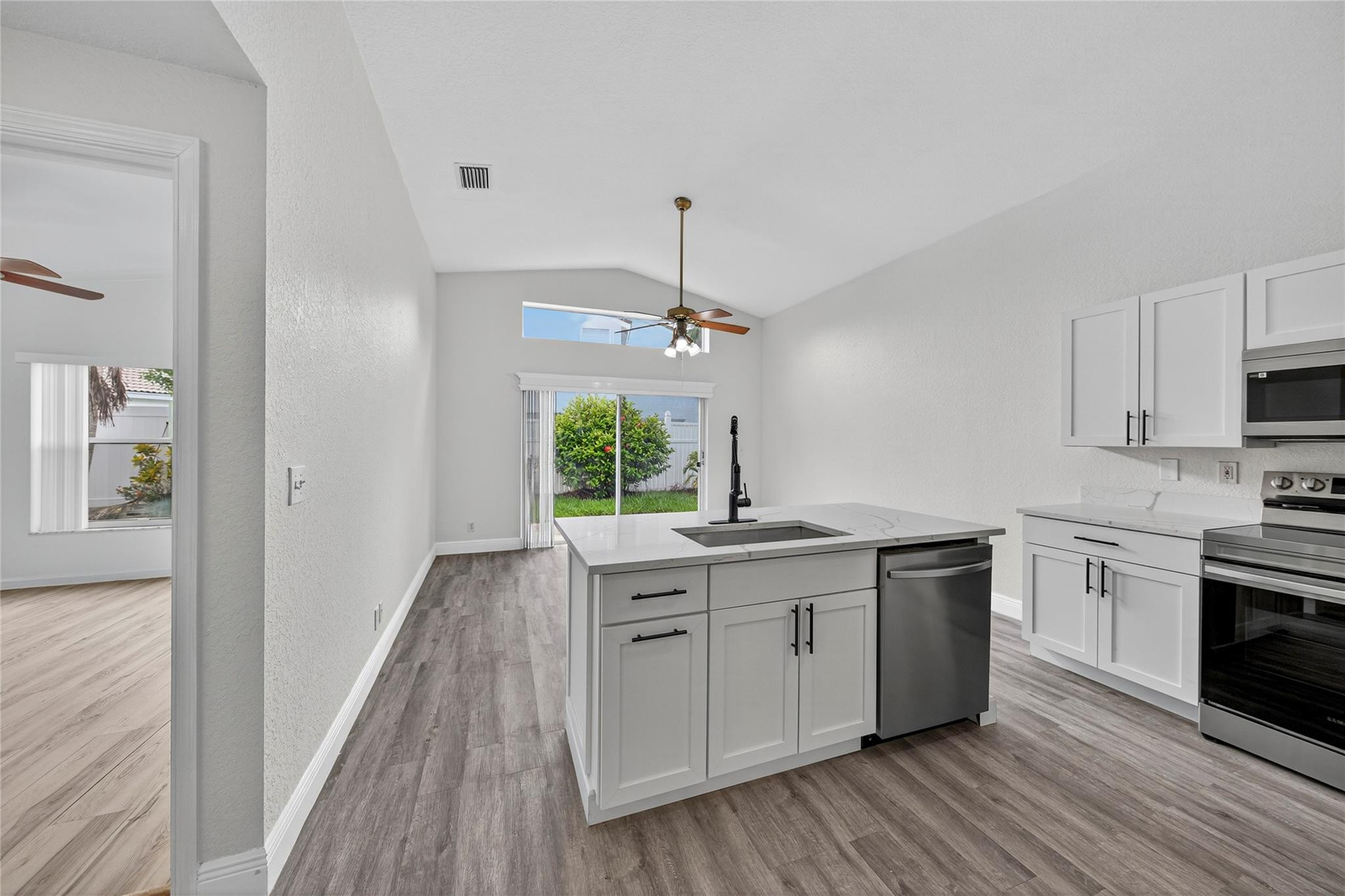2424 Southwest 162nd Avenue Miramar, FL 33027 - Photo 9 of 44 a kitchen with kitchen island granite countertop a sink cabinets and wooden floor