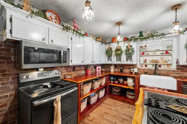 a kitchen with stainless steel appliances kitchen island granite countertop a stove a sink and a microwave