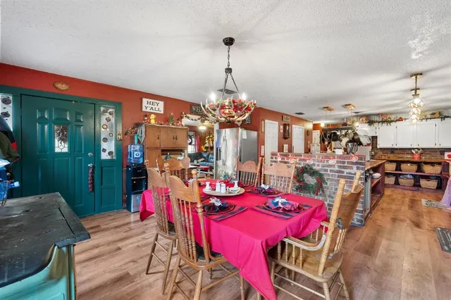 a view of a dining room and livingroom with furniture wooden floor a chandelier