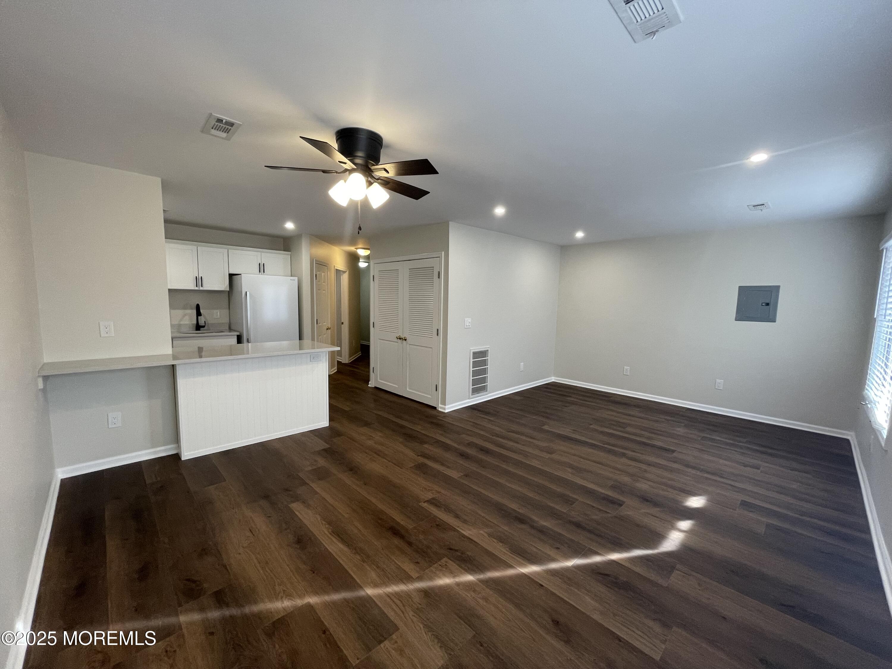 a view of a kitchen with wooden floor and a ceiling fan