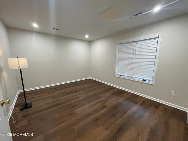 a view of a room with wooden floor and windows