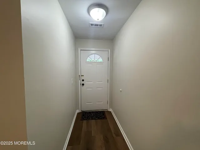 a kitchen with cabinets appliances wooden floor and a window