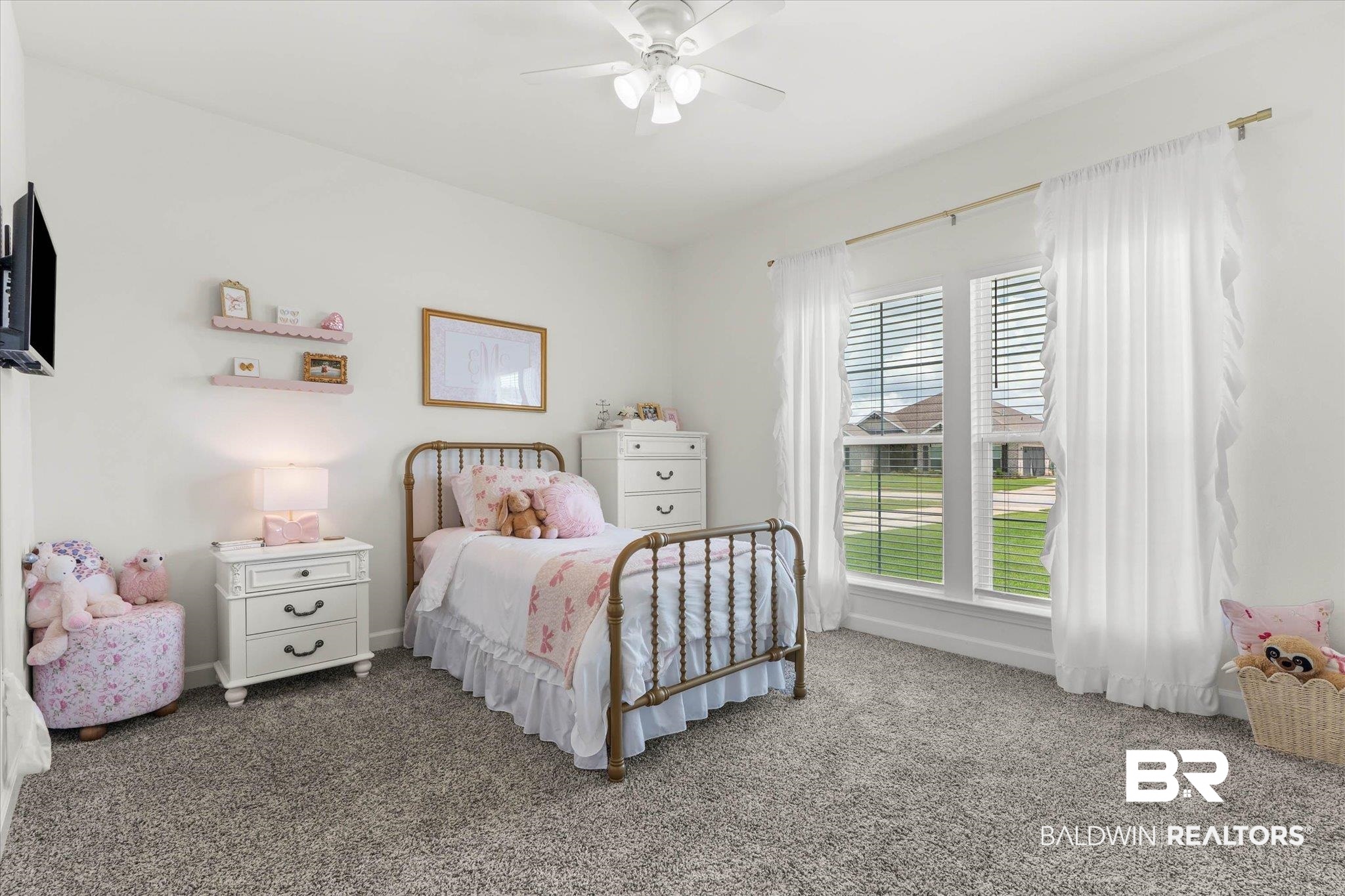 9074 Moses Way Theodore, AL 36582 - Photo 29 of 52 Carpeted room featuring a ceiling fan, two windows with blinds and sheer curtains, and a wall-mounted television