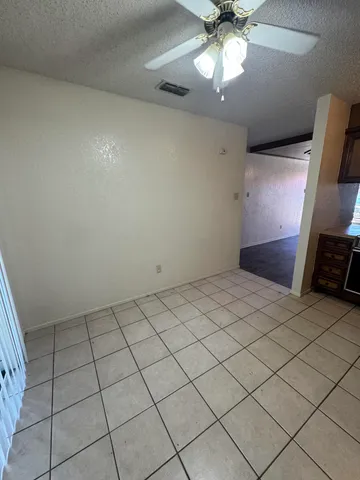 en empty room with ceiling fan and window