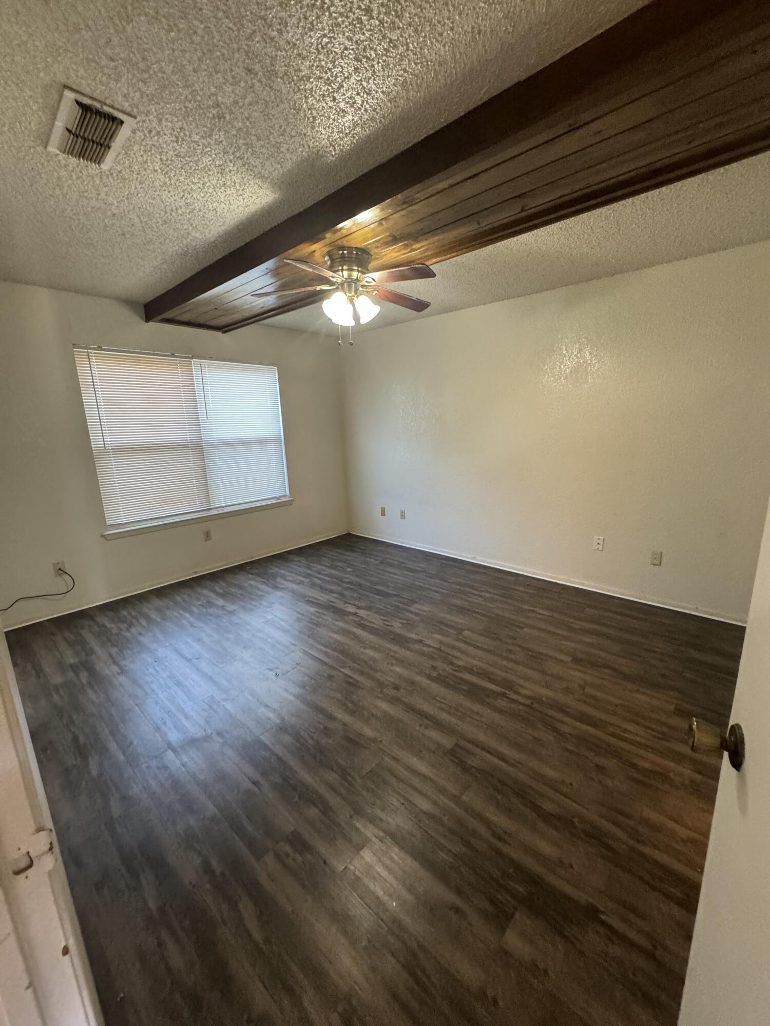 6111 36th Street, Unit C Lubbock, TX 79407 - Photo 4 of 6 a view of empty room with wooden floor and fan