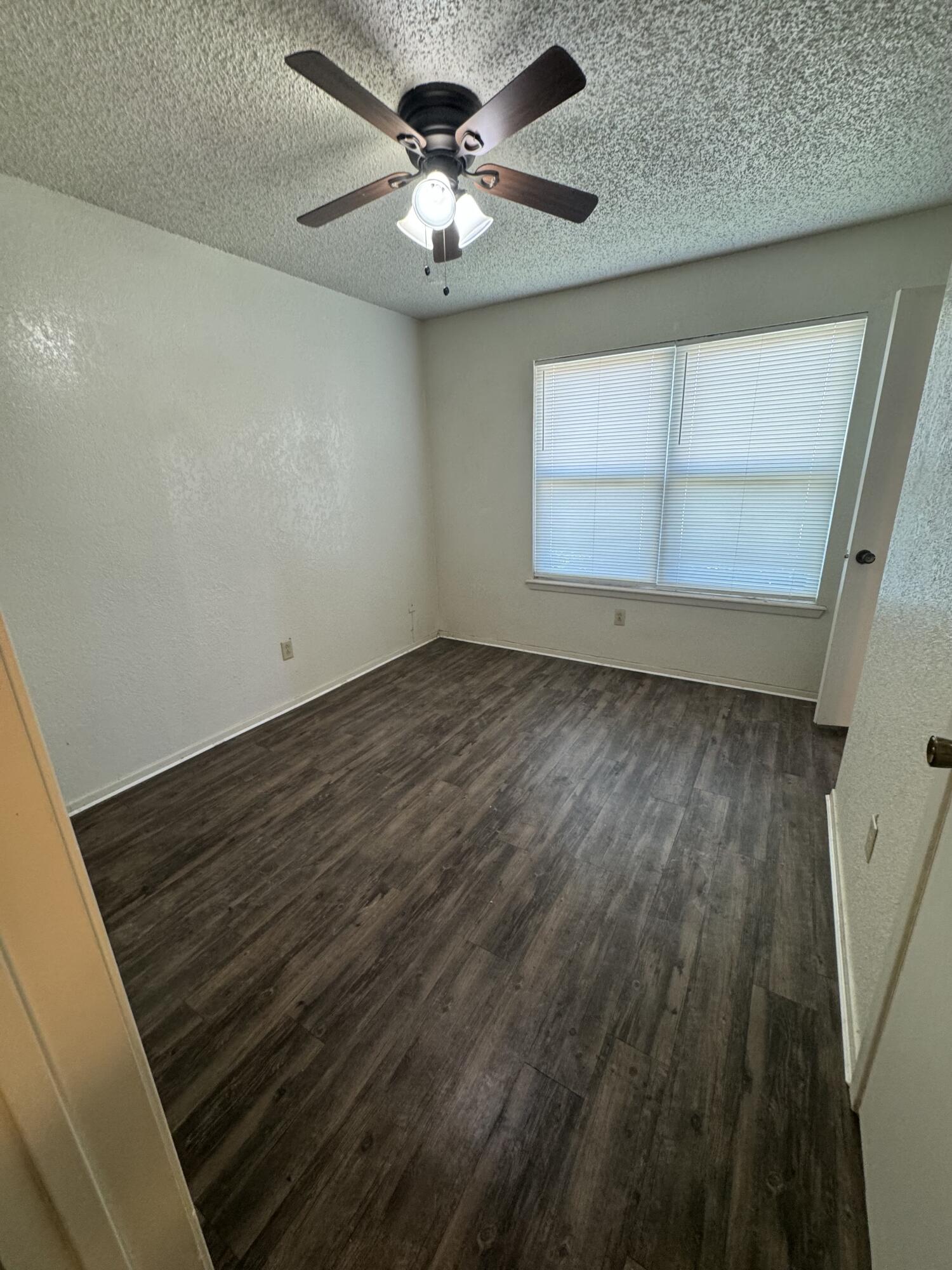 6111 36th Street, Unit C Lubbock, TX 79407 - Photo 6 of 6 en empty room with wooden floor and windows