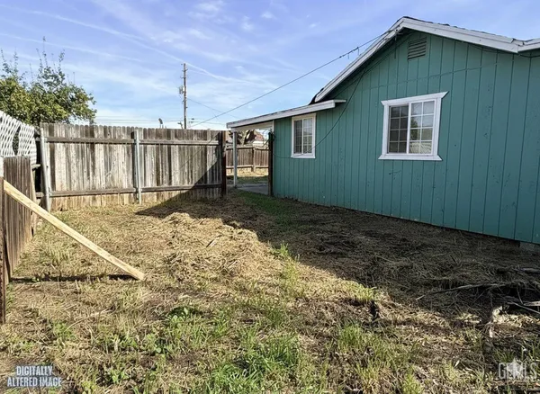 a backyard of a house with a small yard and wooden fence