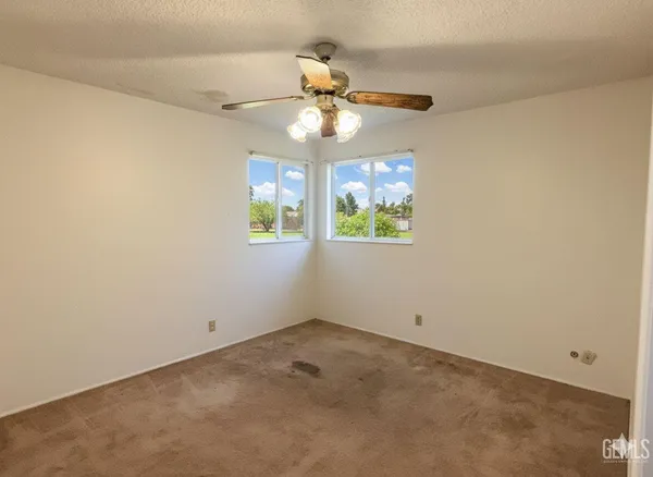 an empty room with a window and a fan