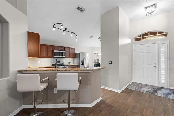 a kitchen with kitchen island granite countertop a sink cabinets and wooden floor