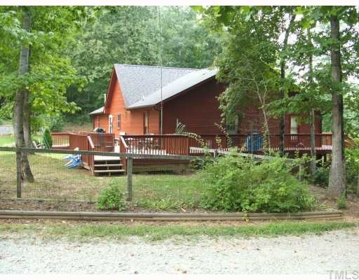1055 Johnny Shaw Road Moncure, NC 27559 - Photo 2 of 12 View of back area with deck and fenced arear for kids play area and family pets.
