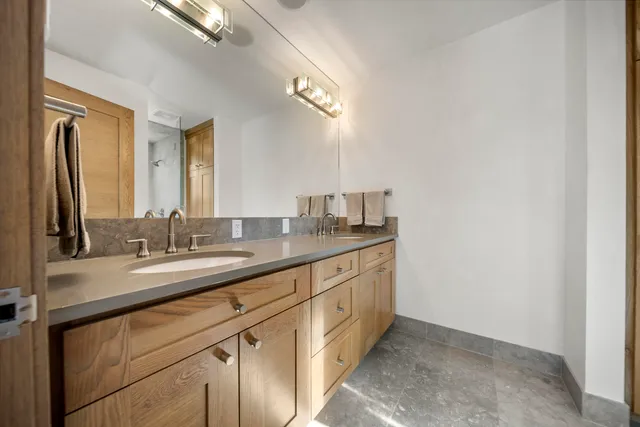 a bathroom with a double vanity sink and a mirror