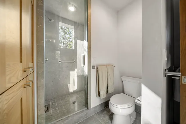a bathroom with a granite countertop toilet and a shower