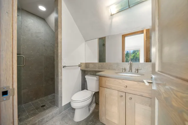 a bathroom with a granite countertop sink a toilet and a mirror