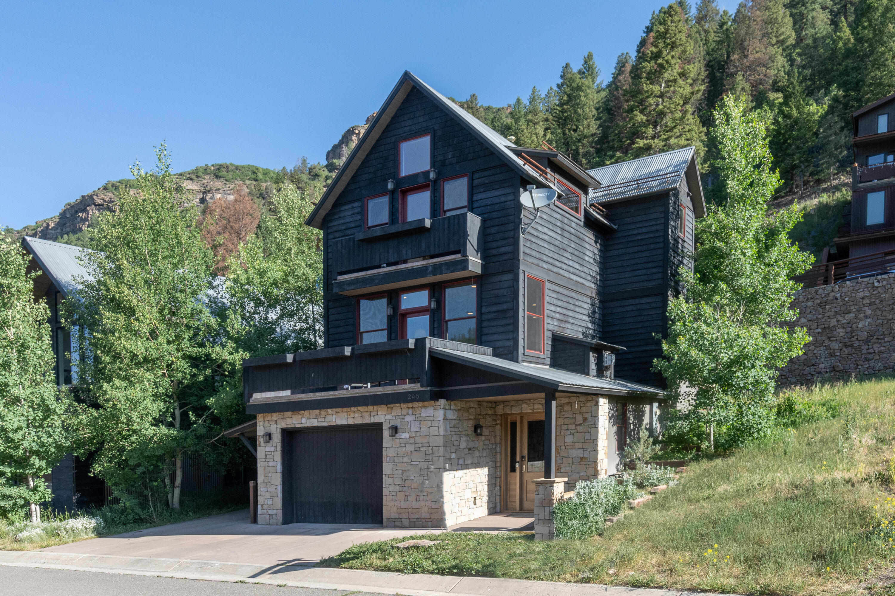 245 South Sunset Ridge Drive Telluride, CO 81435 - Photo 3 of 26 a front view of a house with a garden