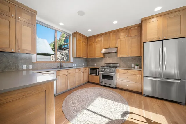 a kitchen with stainless steel appliances a refrigerator sink and cabinets