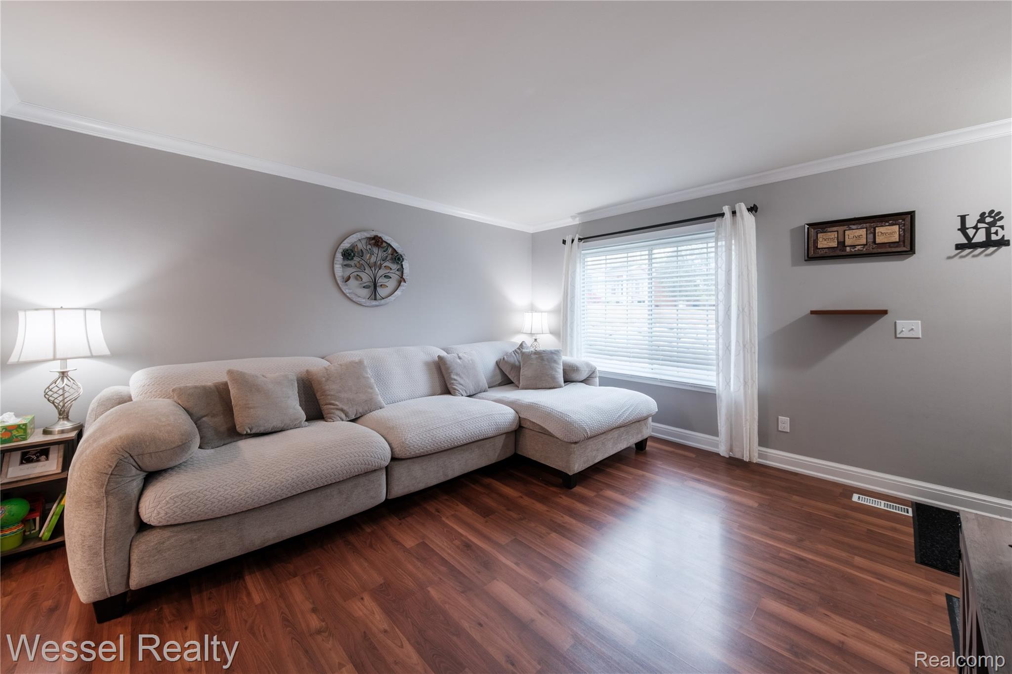 67976 Van Dyke Road, Unit 8 Washington, MI 48095 - Photo 5 of 27 Living room featuring crown molding and wood finished floors