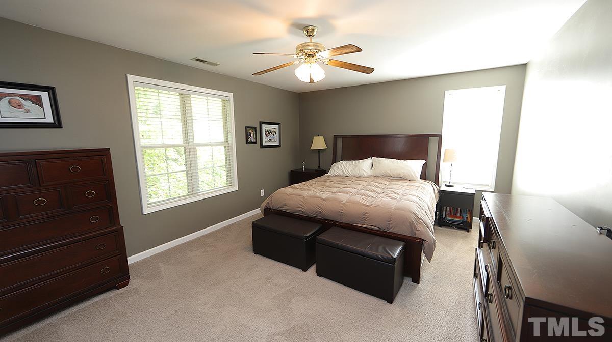 8604 Clivedon Drive Raleigh, NC 27615 - Photo 11 of 16 a bedroom with a bed and a chandelier