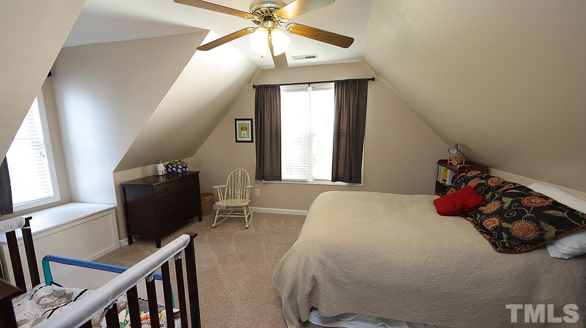 8604 Clivedon Drive Raleigh, NC 27615 - Photo 15 of 16 a bedroom with a bed and a chandelier