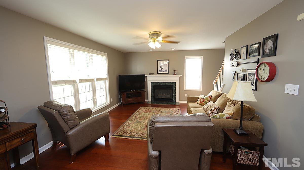 8604 Clivedon Drive Raleigh, NC 27615 - Photo 9 of 16 a living room with furniture a large window and a fireplace