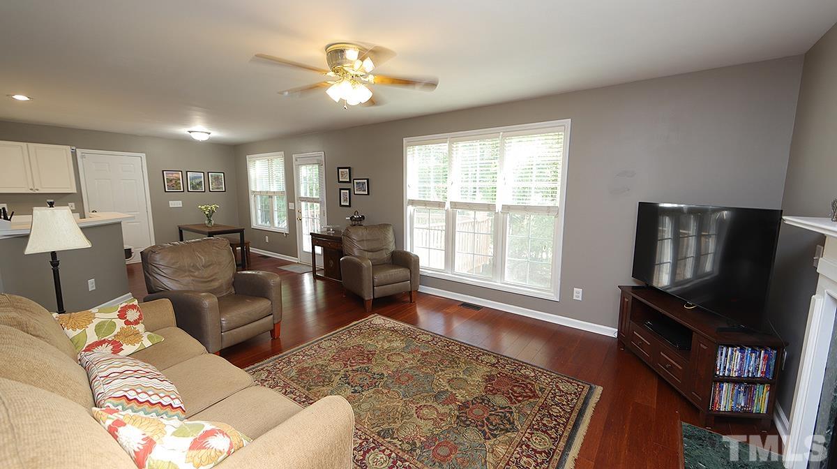 8604 Clivedon Drive Raleigh, NC 27615 - Photo 10 of 16 a living room with furniture flat screen tv and a fireplace