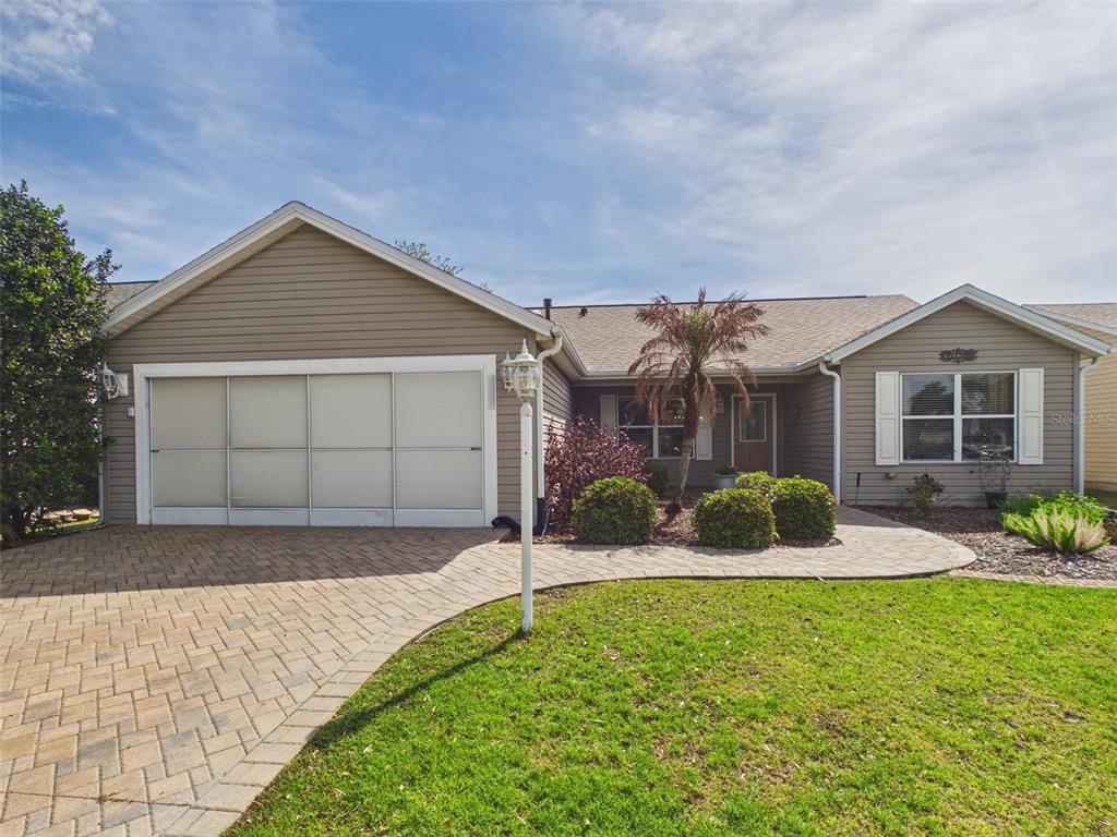 2297 Welcome Way The Villages, FL 32162 - Photo 1 of 36 a front view of a house with a yard and garage
