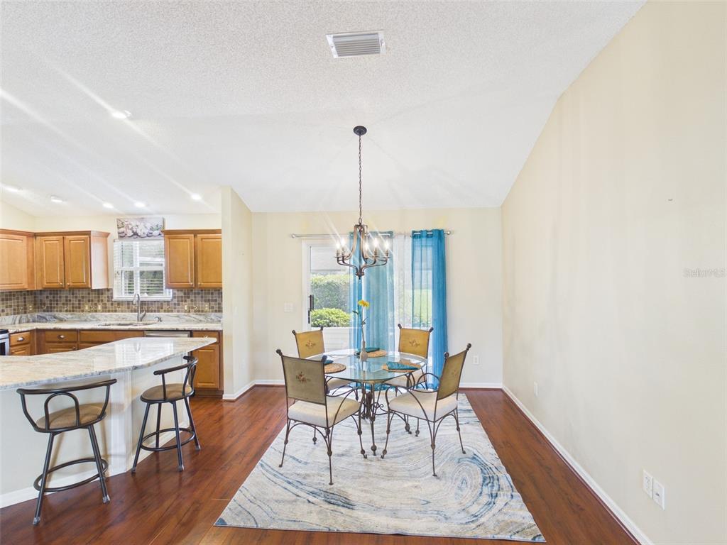 2297 Welcome Way The Villages, FL 32162 - Photo 18 of 36 a dining room with furniture a rug and a chandelier