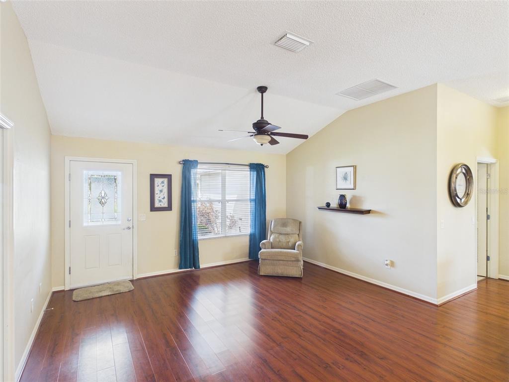 2297 Welcome Way The Villages, FL 32162 - Photo 19 of 36 a view of a livingroom with wooden floor and a ceiling fan