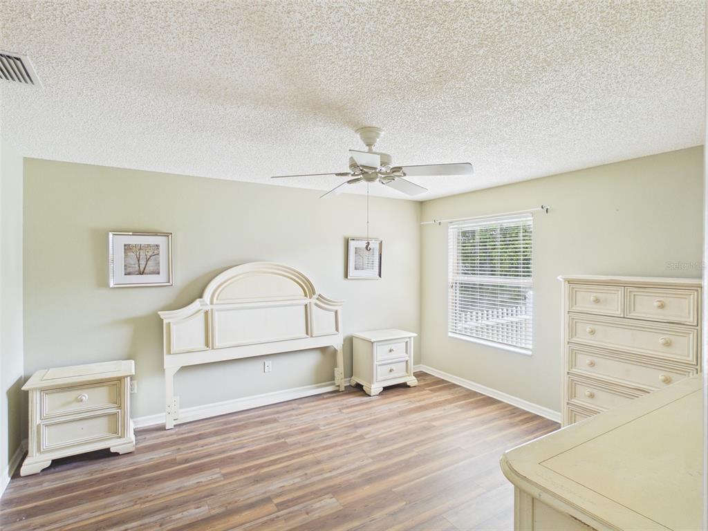 2297 Welcome Way The Villages, FL 32162 - Photo 20 of 36 a view of a livingroom with wooden floor and a ceiling fan