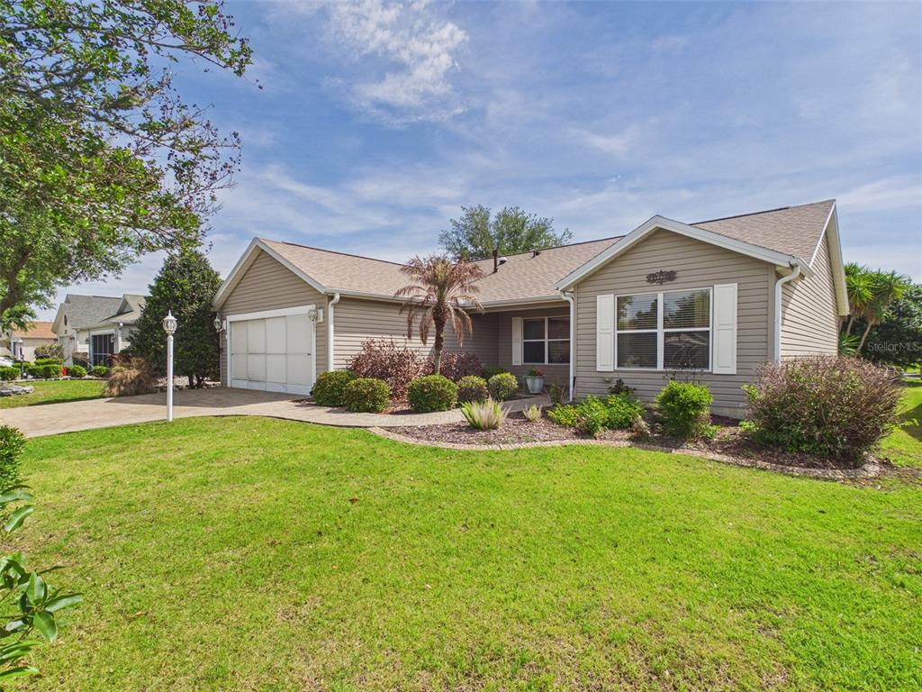 2297 Welcome Way The Villages, FL 32162 - Photo 2 of 36 a front view of a house with a yard and porch