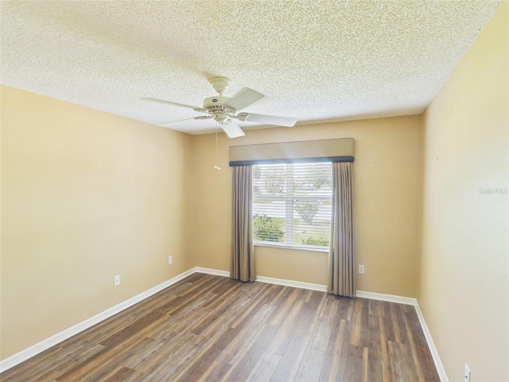 2297 Welcome Way The Villages, FL 32162 - Photo 30 of 36 an empty room with a hardwood and ceiling fan