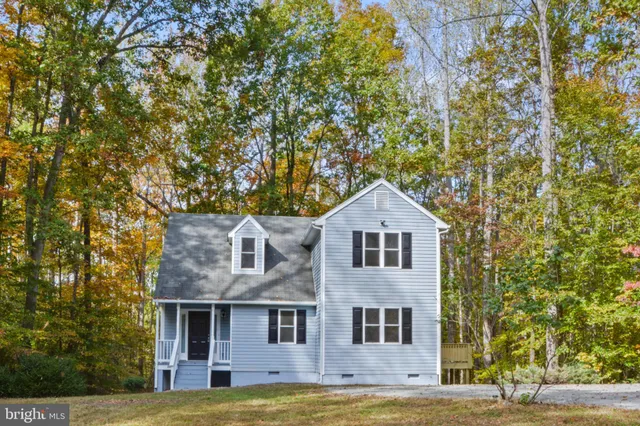 a view of a brick house with a big yard and large trees