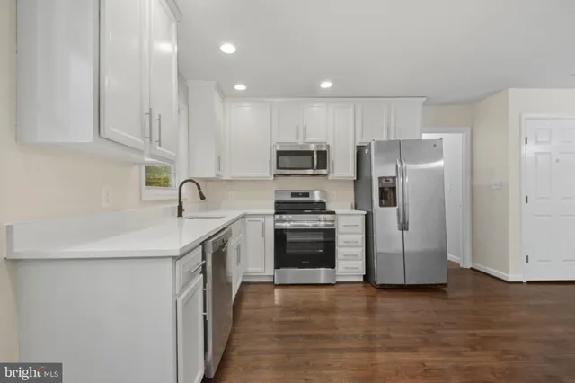 a kitchen with stainless steel appliances granite countertop a refrigerator sink and stove