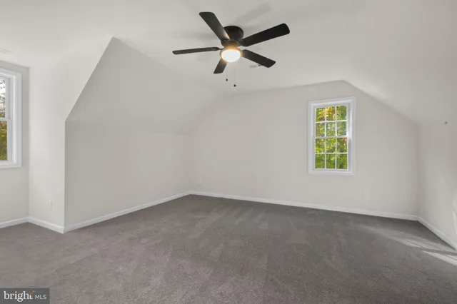 an empty room with a window and a ceiling fan
