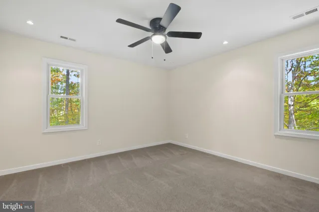 an empty room with window and ceiling fan