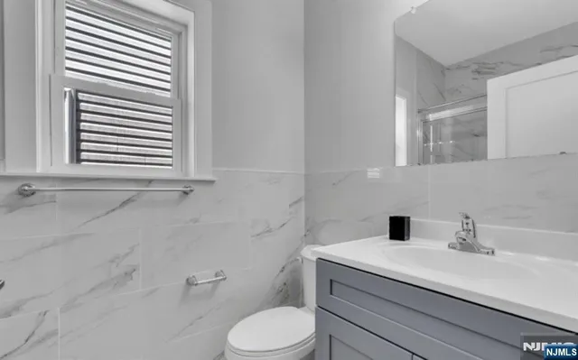 a bathroom with a sink a toilet and a mirror