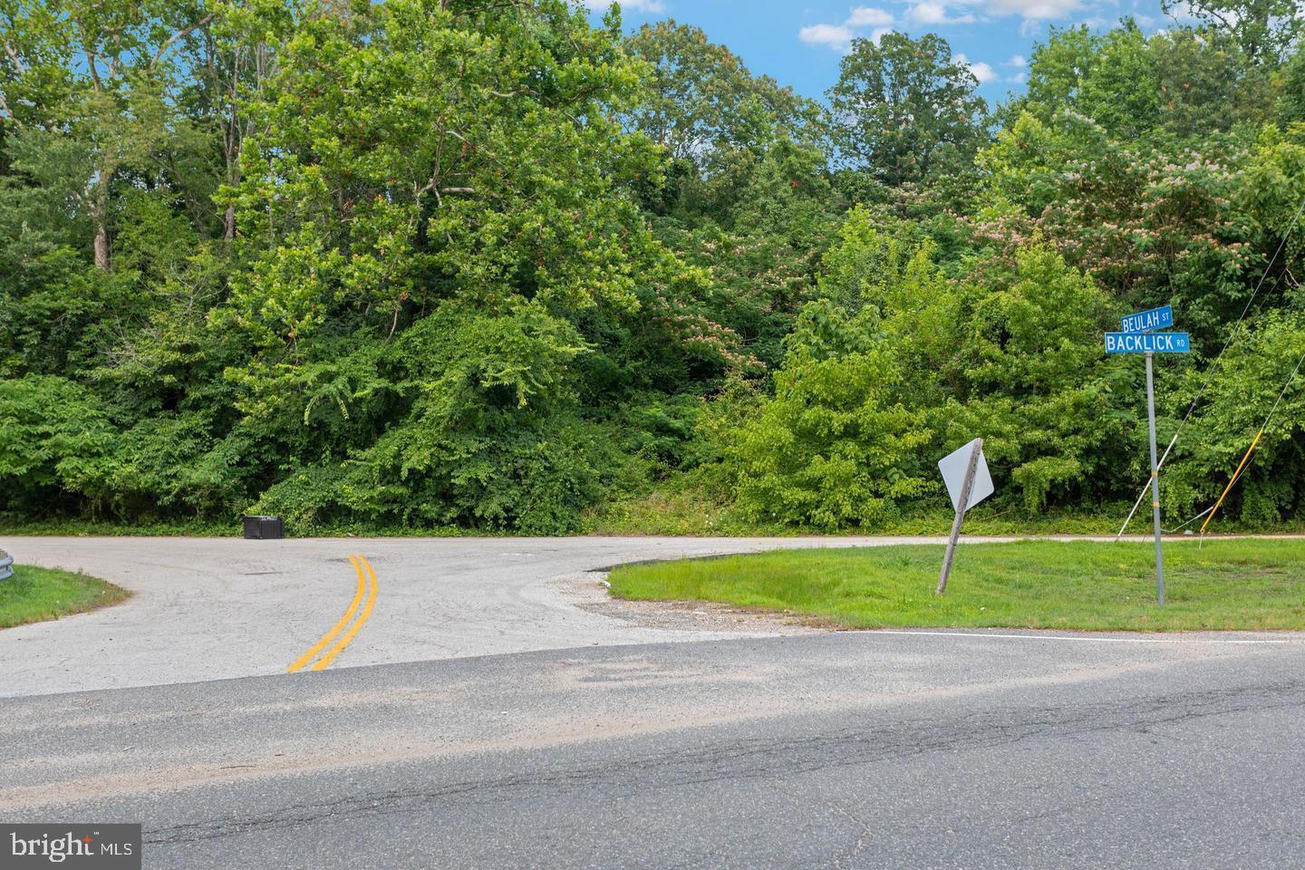 9005 Backlick Road Fort Belvoir, VA 22060 - Photo 13 of 25 a small white house with a yard and a large parking space