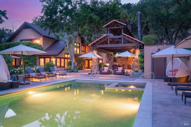 a view of swimming pool with tables and chairs under an umbrella