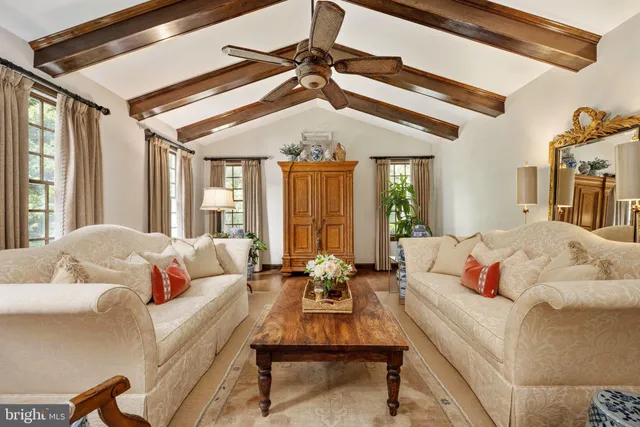 a view of a dining room and livingroom with furniture wooden floor a chandelier