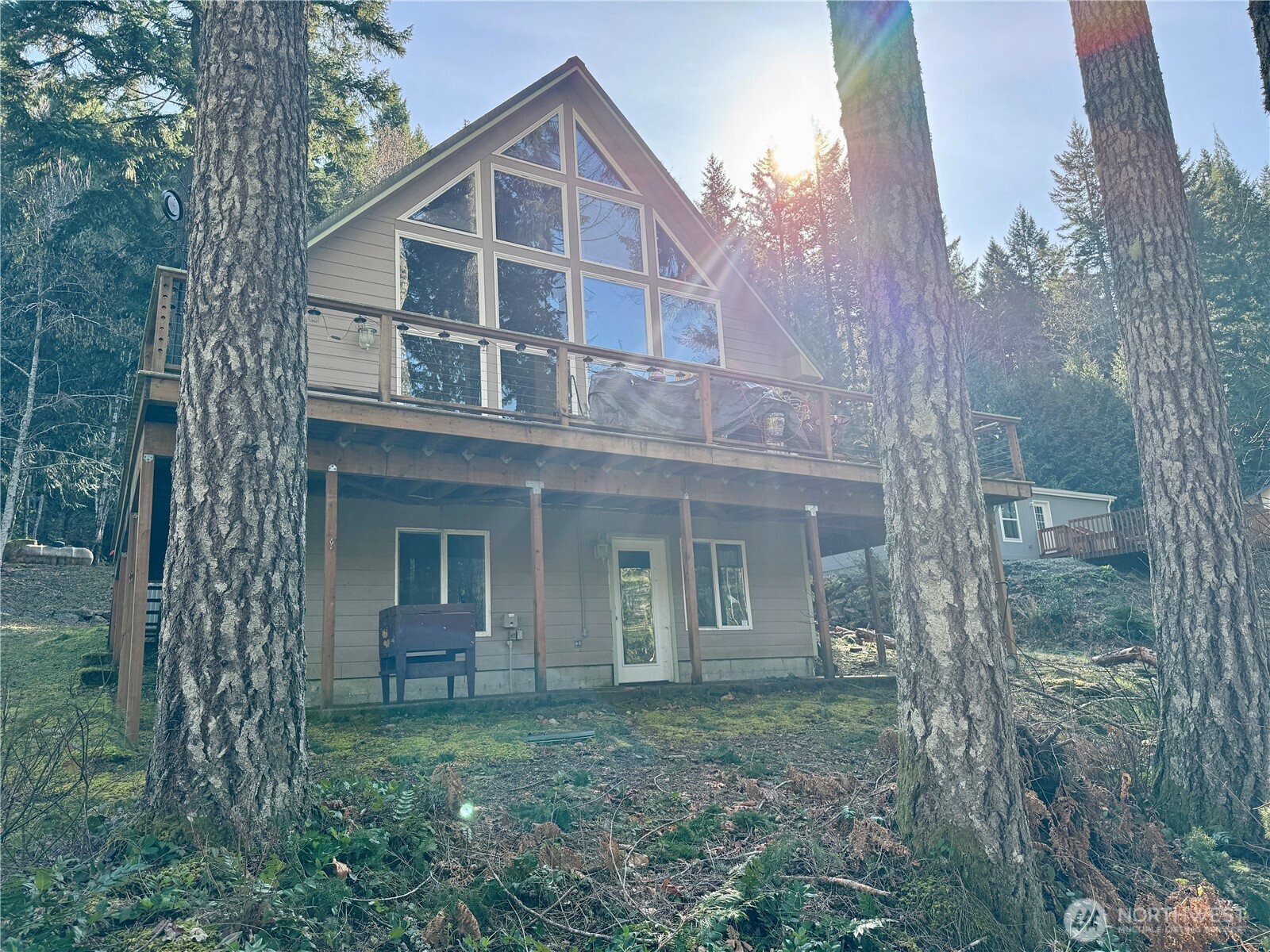 70 Rim View Place Hoodsport, WA 98548 - Photo 27 of 35 a view of a brick house with large windows and a yard