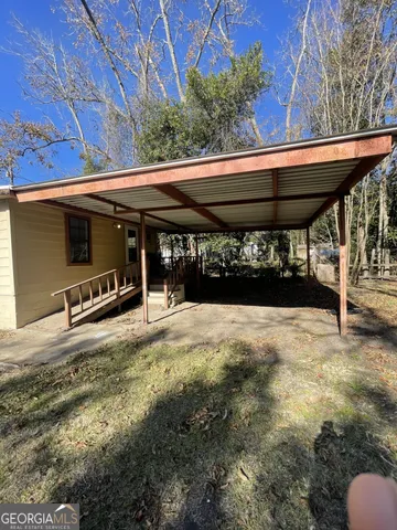 a backyard of a house with barbeque oven table and chairs