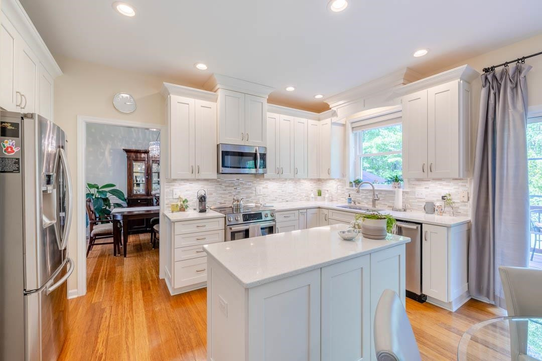 7402 Leapale Lane Durham, NC 27713 - Photo 11 of 41 a kitchen with a sink a counter top space stainless steel appliances cabinets and a window