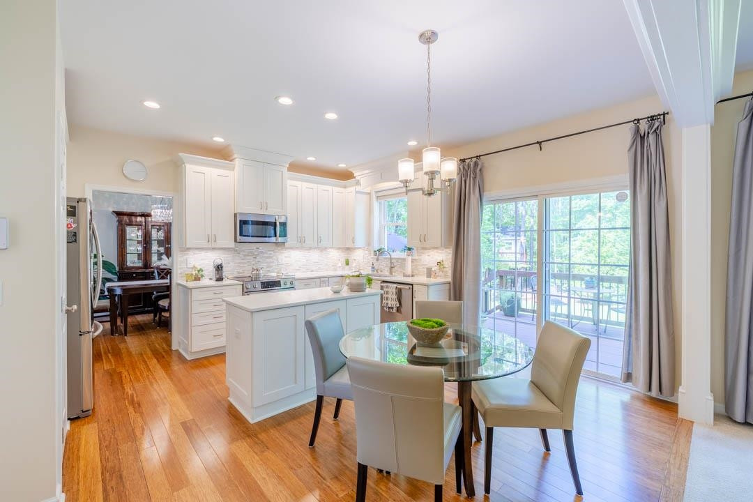 7402 Leapale Lane Durham, NC 27713 - Photo 12 of 41 a kitchen with a dining table chairs and white cabinets
