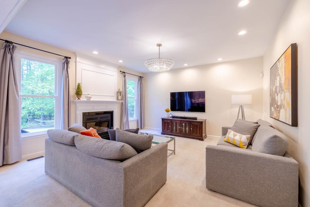 7402 Leapale Lane Durham, NC 27713 - Photo 14 of 41 a living room with furniture a flat screen tv and a fireplace