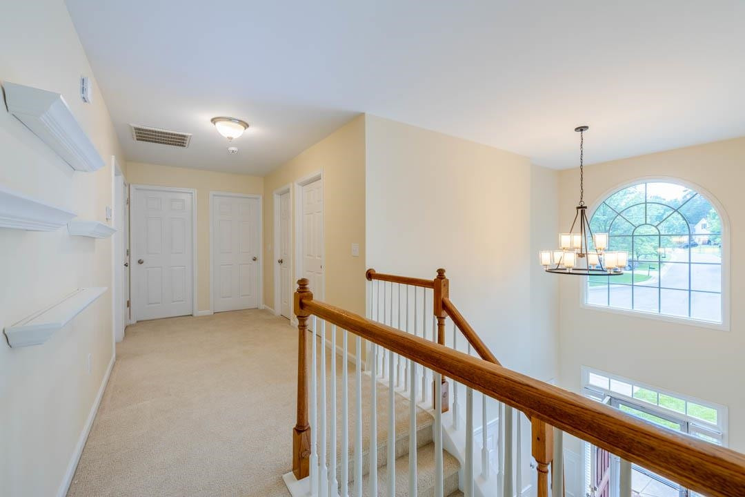 7402 Leapale Lane Durham, NC 27713 - Photo 20 of 41 a view of a hallway to an entryway with wooden floor