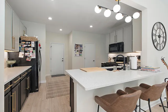 a kitchen that has a table chairs and a refrigerator
