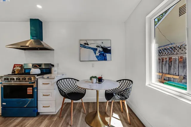 a kitchen with stainless steel appliances a stove a table and chair