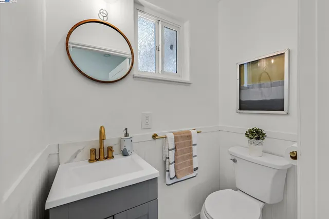 a bathroom with a toilet a sink and mirror