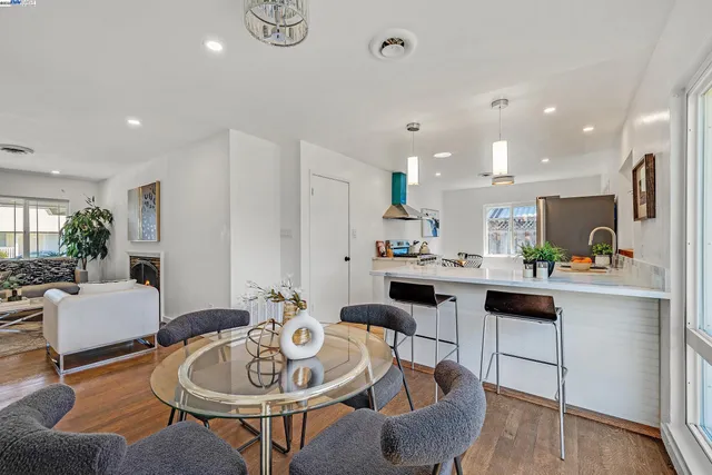 a kitchen with stainless steel appliances kitchen island granite countertop a stove a sink a dining table and chairs